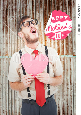 Composite image of geeky hipster crying and holding heart card Composite image of geeky hipster crying and holding heart card 15070947