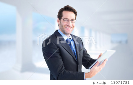 Composite image of businessman looking at the camera while using Composite image of businessman looking at the camera while using 15071781
