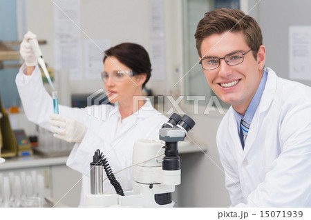 Scientists working with microscope and test tube 15071939