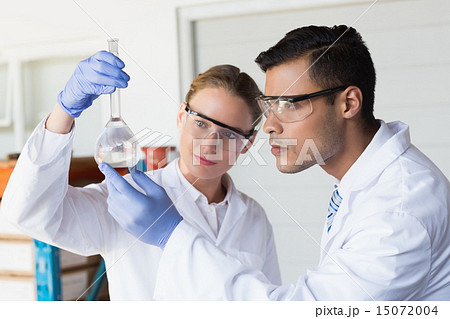 Concentrated scientists looking at beaker 15072004