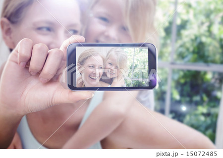 Composite image of hand holding smartphone showing 15072485