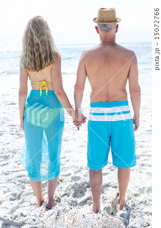 Happy couple standing by the sea and holding hands 15072766