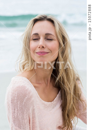 Smiling pretty blonde relaxing on the sand Smiling pretty blonde relaxing on the sand 15072888