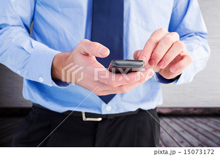 Composite image of close up of a businessman using a smartphone Composite image of close up of a businessman using a smartphone 15073172