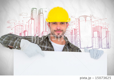 Composite image of handyman holding and pointing at blank board 15073625