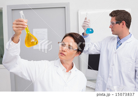 Scientists looking attentively at beakers 15073837