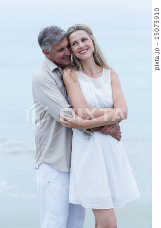 Happy couple standing by the sea and hugging each other 15073910