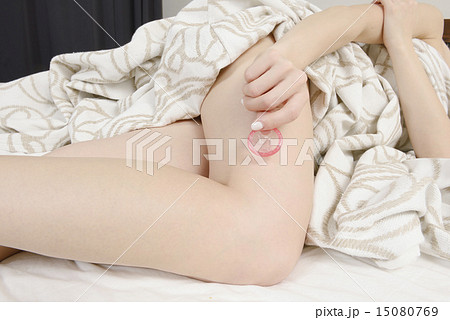 コンドームを持つ若い女性の手 15080769