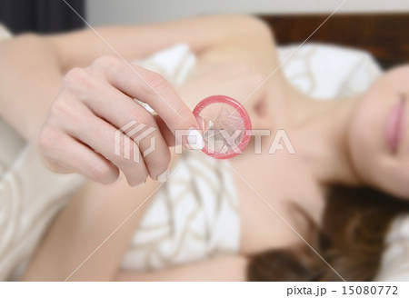 コンドームを持つ若い女性の手 15080772