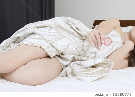 コンドームを持つ若い女性の手 15080775