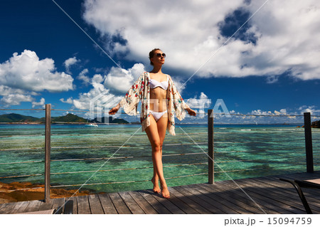 Woman on a beach jetty at Seychelles, La Digue. 15094759