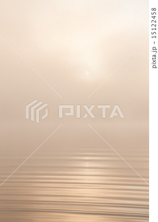 Morning sun through fog at lake 15122458