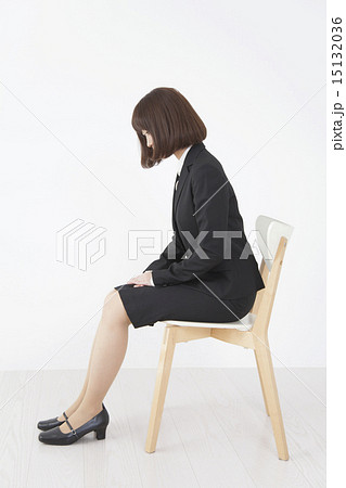 椅子に座ってお辞儀するビジネス女性イメージの写真素材