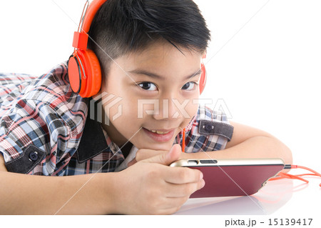 Asian boy ware headphone and playing the cell phone 15139417