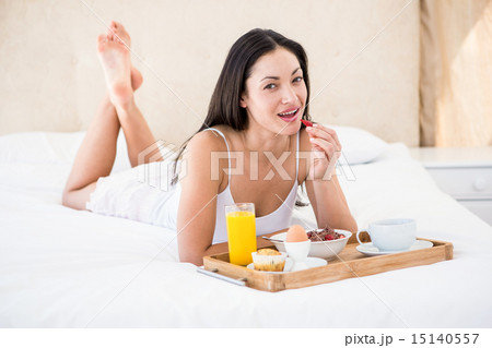 Pretty brunette eating her breakfast on bed Pretty brunette eating her breakfast on bed 15140557