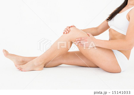 Sitting woman touching her painful knee Sitting woman touching her painful knee 15141033