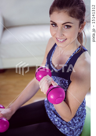Fit woman lifting dumbbells on exercise ball Fit woman lifting dumbbells on exercise ball 15141312