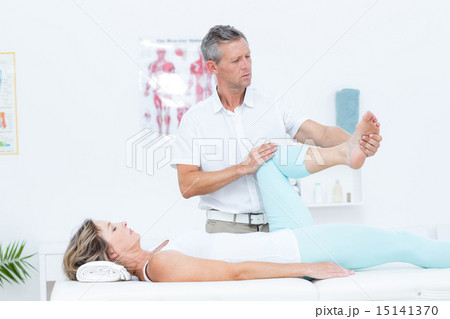 Doctor stretching his patients leg Doctor stretching his patients leg 15141370