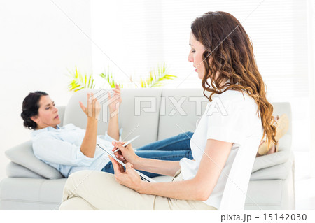 Therapist listening her patient and taking notes Therapist listening her patient and taking notes 15142030