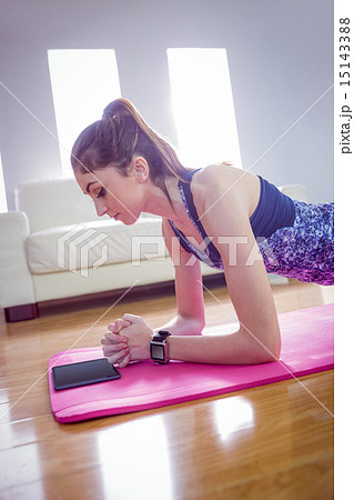 Fit woman doing plank on mat 15143388