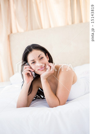Pretty brunette calling on bed 15143819