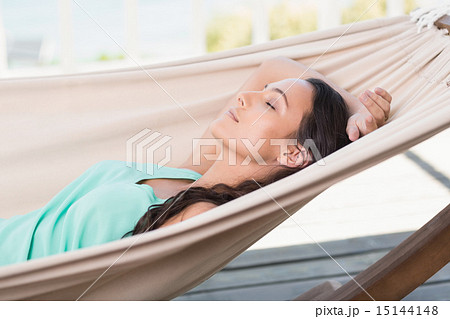Pretty brunette relaxing on a hammock 15144148