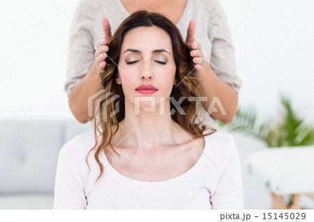 Calm woman receiving reiki treatment 15145029