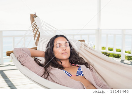 Pretty brunette relaxing on a hammock 15145446