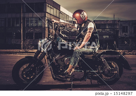Biker and his bobber style motorcycle on a city streets Biker and his bobber style motorcycle on a city streets 15148297