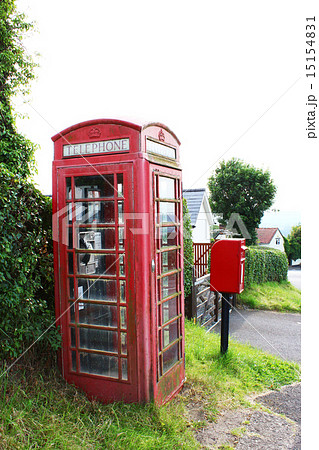 イギリス田舎町の赤い電話ボックスの写真素材