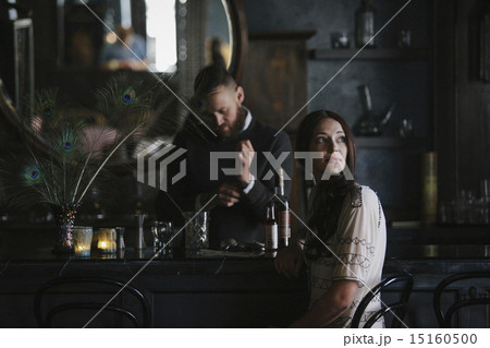 A woman and a bartender talking, and mixing drinks.  15160500