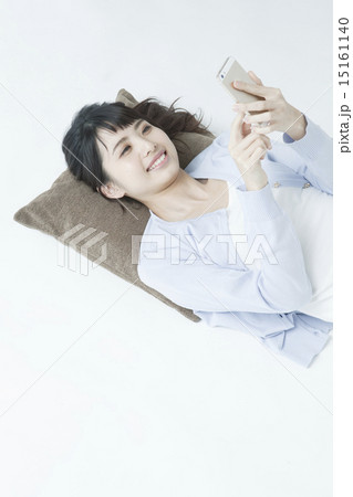 寝ながらスマホを使う女性 寝ながらスマホを使う女性 15161140