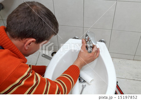 Plumbing, plumber fixing water tap on bidet 15197852