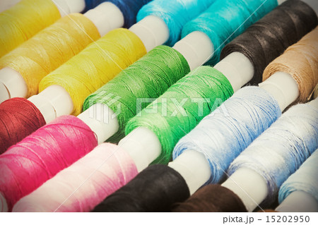 Multicolor sewing threads on wooden background Multicolor sewing threads on wooden background 15202950