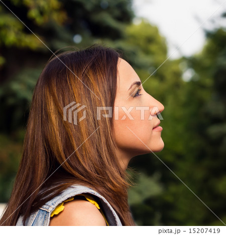 Young women looking up - against background of green park Young women looking up - against background of green park 15207419