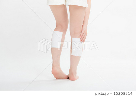 足に湿布薬を貼った女性の写真素材