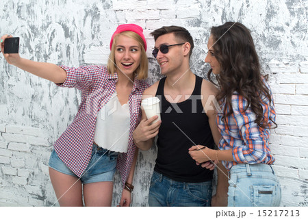 two women and man friends taking selfie together wearing summer clothes jeans shorts jeanswear two women and man friends taking selfie together wearing summer clothes jeans shorts jeanswear 15217213