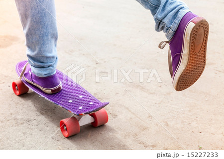 Feet of riding skateboarder in jeans and gumshoes Feet of riding skateboarder in jeans and gumshoes 15227233