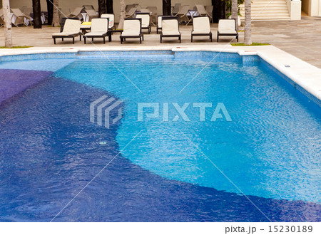 Empty chaise lounges near  pool 15230189