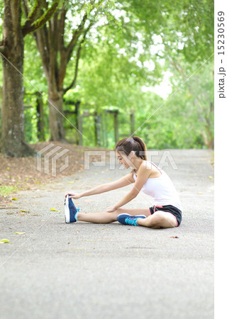 Young Chinese woman stretching in a park Young Chinese woman stretching in a park 15230569