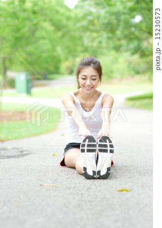 Young Chinese woman stretching in a park Young Chinese woman stretching in a park 15230573