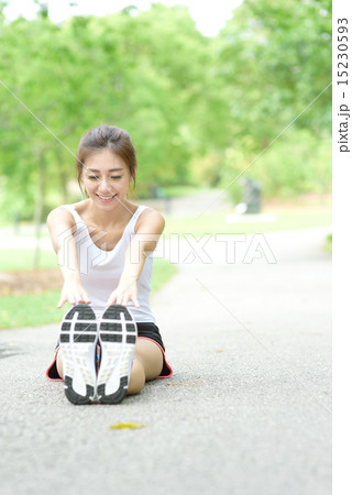 Young Chinese woman stretching in a park Young Chinese woman stretching in a park 15230593