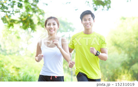 Young Chinese man and woman running in a park Young Chinese man and woman running in a park 15231019