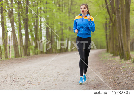 Young beautiful woman running on a trail Young beautiful woman running on a trail 15232387