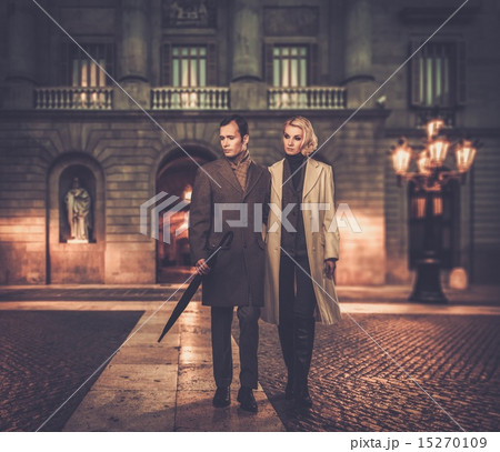 Elegant couple in coats against building facade Elegant couple in coats against building facade 15270109