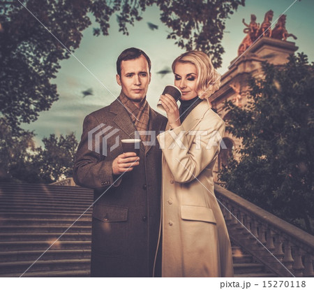 Elegant couple outdoors with cups of hot drink 15270118