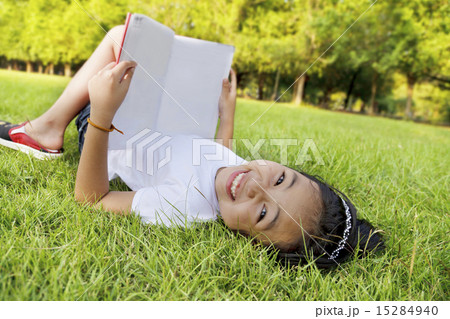 Asian little girl relax and reading a book in the park 15284940