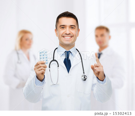 smiling male doctor in white coat with tablets smiling male doctor in white coat with tablets 15302413