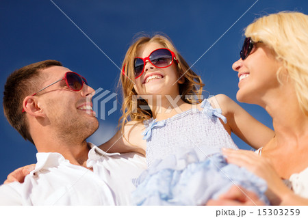 happy family in sunglasses over blue sky 15303259