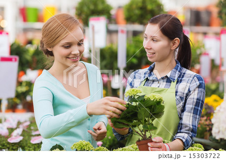 happy women choosing flowers in greenhouse 15303722